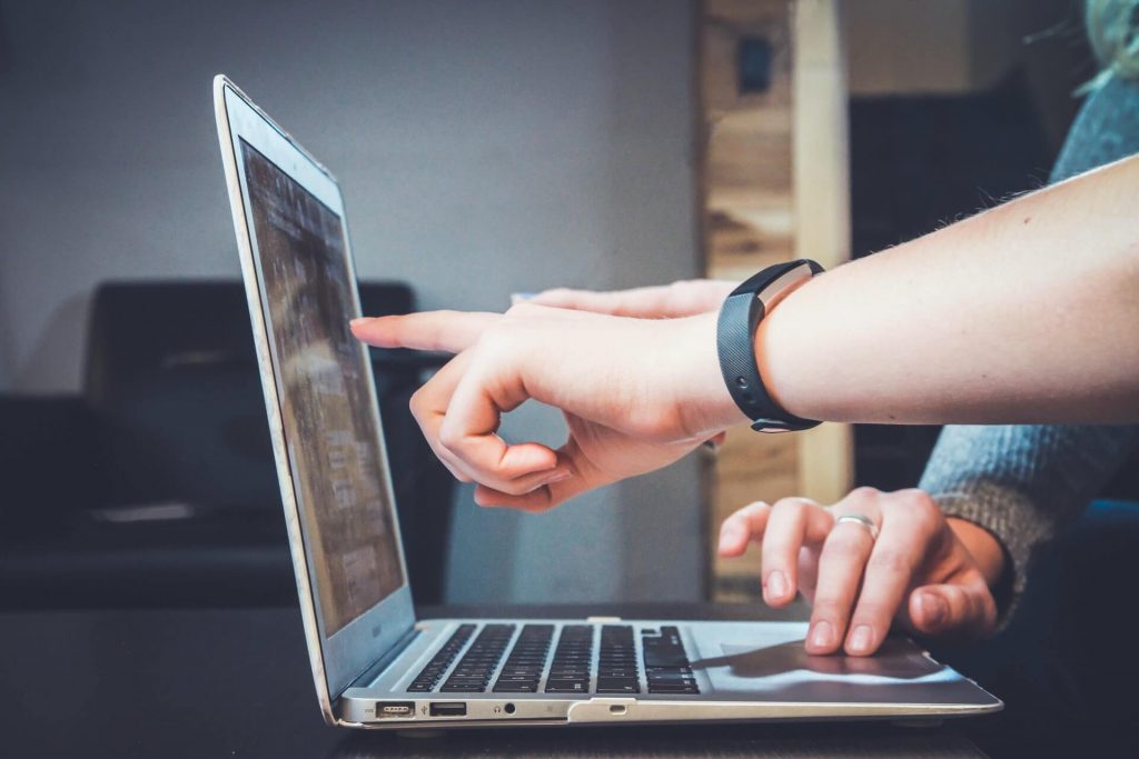 people showing hands to laptop